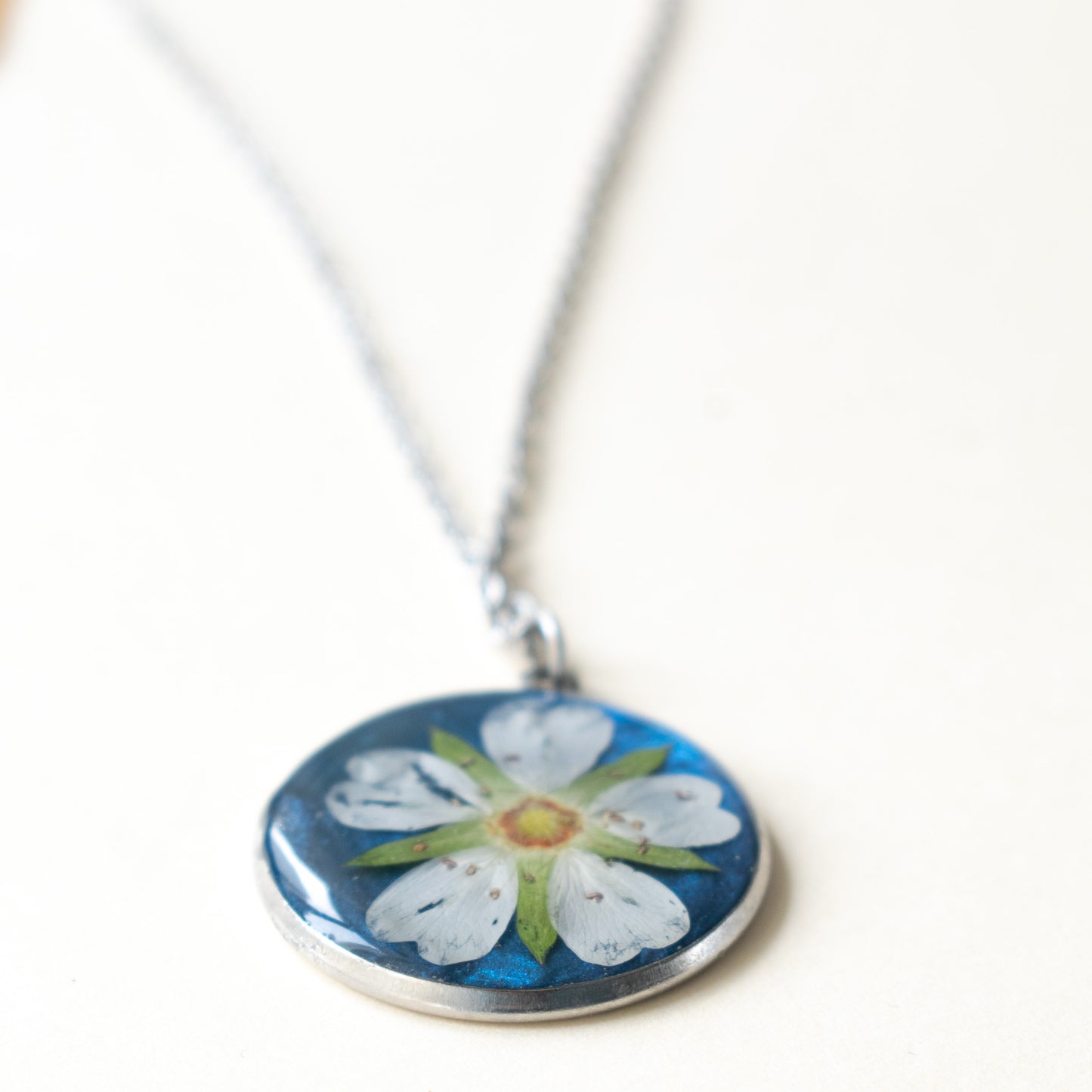 Colgante con flor blanca