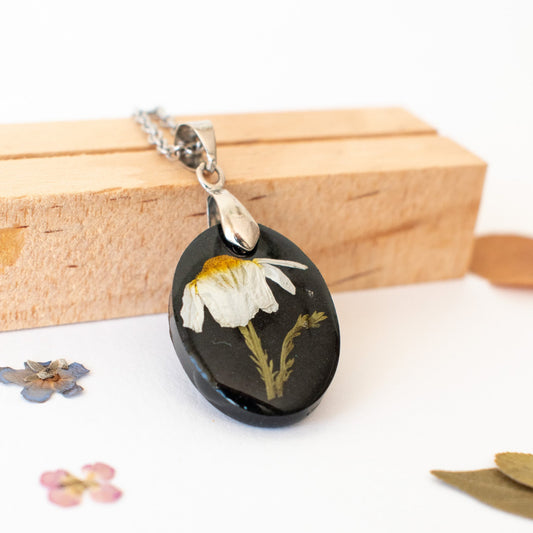 colgante negro con flor de manzanilla