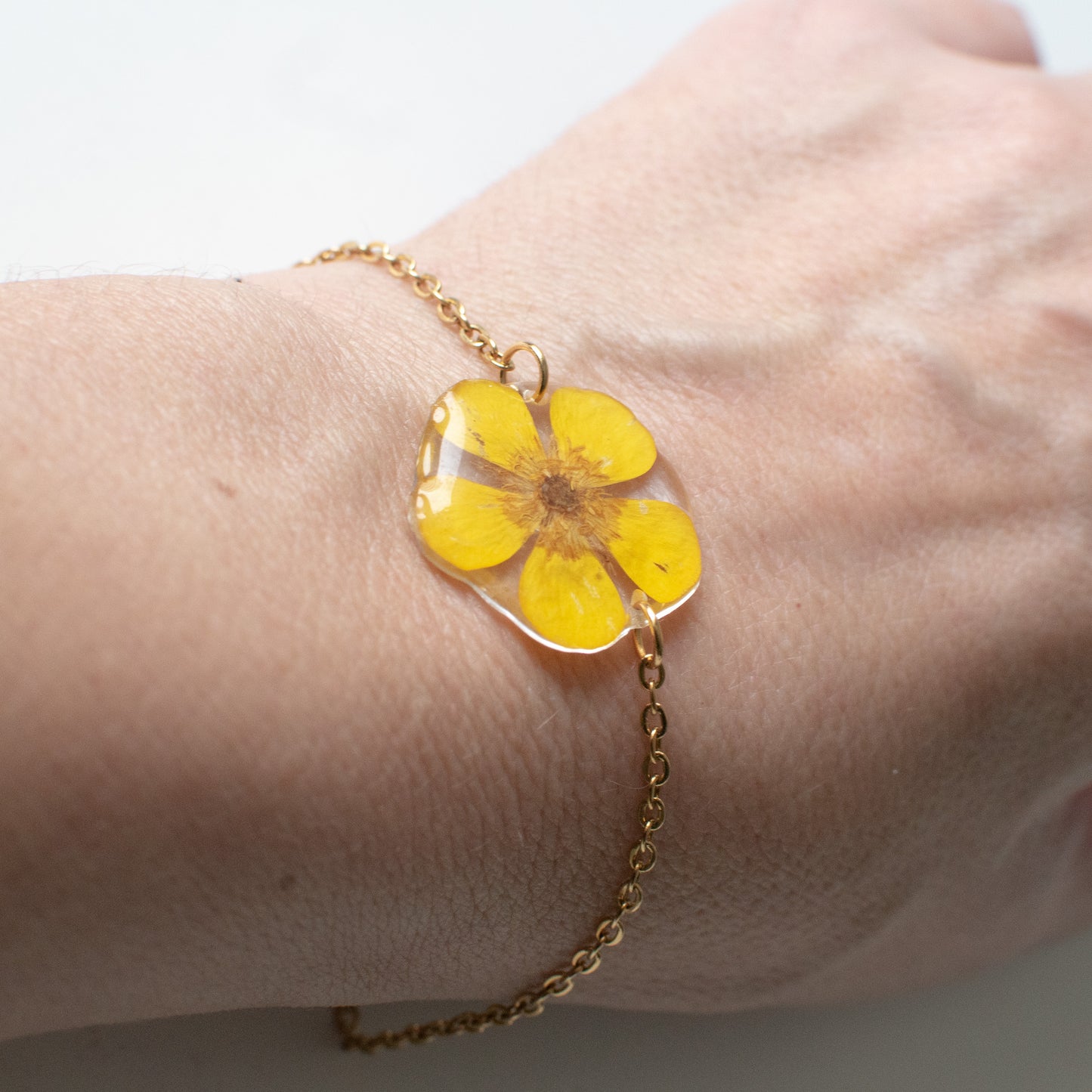 Pulsera de acero con flor botón de oro